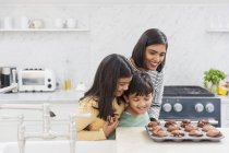 Mère et les enfants de cuisson de muffins au chocolat — Photo de stock