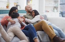 Щаслива, ласкава сім'я на дивані у вітальні — стокове фото