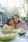 Portrait happy mother an daughter at dinner table — Stock Photo