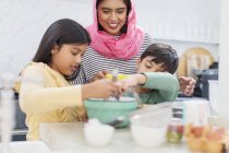Mère dans la cuisson hijab avec des enfants dans la cuisine — Photo de stock