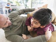 Playful father and son on floor — Stock Photo