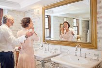 Couple getting ready in hotel bathroom mirror — Stock Photo