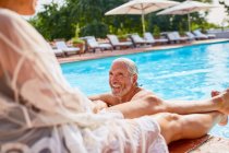 Casal feliz relaxante na piscina resort ensolarado — Fotografia de Stock