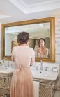 Frau macht sich vor Hotelbadezimmerspiegel fertig — Stockfoto