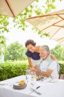 Älteres Paar mit Smartphone im Terrassenrestaurant — Stockfoto