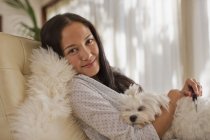 Портрет улыбающейся молодой женщины, обнимающейся с собакой — стоковое фото