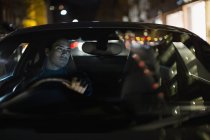 Hombre conduciendo coche por la noche - foto de stock