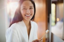 Porträt glückliche junge Frau beim Zähneputzen im Badezimmer — Stockfoto