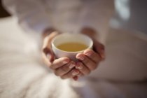 Chiudi donna coppettazione tè caldo — Foto stock