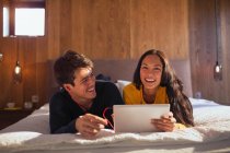Ritratto coppia felice con cuffie condividere laptop sul letto — Foto stock