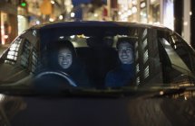 Casal sorridente dirigindo na rua da cidade — Fotografia de Stock