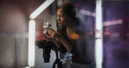 Женщина-фотограф рассматривает прототип — стоковое фото