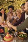 Amici che festeggiano, brindando champagne a cena festa in giardino — Foto stock