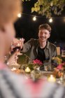 Hombre feliz tostando copa de vino en la fiesta del jardín de la cena - foto de stock