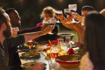 Amici brindare bicchieri di vino a cena festa in giardino — Foto stock