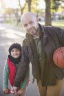 Portrait father and son with basketball in autumn park — Stock Photo