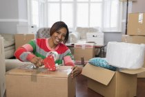 Ritratto sorridente, donna felice taping scatola di cartone, casa in movimento — Foto stock