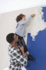 Padre e hijo pintando pared - foto de stock