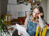 Сосредоточенная молодая женщина, работающая в домашнем офисе, читающая документы — стоковое фото