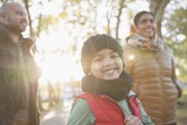 Porträt glücklicher Junge mit Eltern im sonnigen Herbstpark — Stockfoto