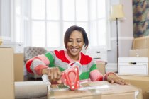 Sorrindo mulher gravando caixas móveis, movendo-se casa — Fotografia de Stock