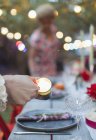 Woman lighting candles for dinner garden party — Stock Photo