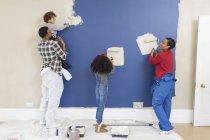 Famiglia pittura muro all'interno di nuova casa — Foto stock