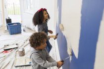 Brother and sister painting wall — Stock Photo