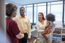 Doctor talking with family in clinic doctors office — Stock Photo