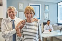 Porträt glückliches Seniorenpaar verlässt Arztpraxis — Stockfoto