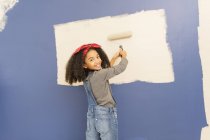 Portrait happy, confident girl painting wall — Stock Photo