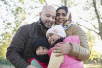 Portrait happy Muslim family hugging in autumn park — Stock Photo