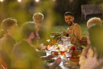 Felice amici godendo cena giardino partito — Foto stock