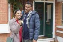 Porträt glückliches Paar mit Hausschlüssel vor neuem Haus — Stockfoto