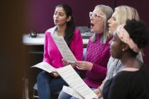 Women choir with sheet music singing in music recording studio — Stock Photo