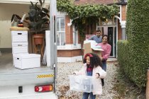 Famille déménagement hors de la maison, chargement fourgon de déménagement dans l'allée — Photo de stock