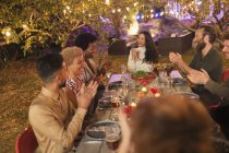 Amici applausi, godendo cena in giardino festa — Foto stock