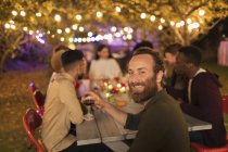 Портрет впевнений чоловік п'є вино, насолоджуючись вечерею садової вечірки — стокове фото