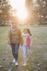 Retrato mãe muçulmana feliz e filha andando no ensolarado parque de outono — Fotografia de Stock