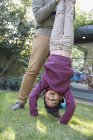 Playful boy hanging upside down in backyard — Stock Photo