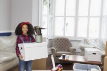 Retrato sorrindo, menina confiante movendo casa, carregando caixa de papelão — Fotografia de Stock