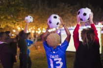 Glückliche Freunde mit Fußballbällen jubeln, Fußballspiel im Hinterhof ansehen — Stockfoto