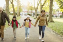 Happy Muslim family holding hands, walking in autumn park — Stock Photo