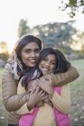 Portrait happy Muslim mother in hijab hugging daughter in park — Stock Photo