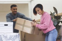 Happy couple moving house, unloading moving van — Stock Photo