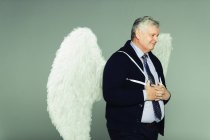 Улыбающийся бизнесмен с ангельскими крыльями — стоковое фото