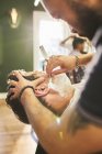 Male barber giving customer a shave in barbershop — Stock Photo