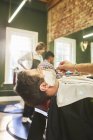 Человек, получающий бритье в парикмахерской — стоковое фото