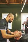 Чоловічий перукар масажує обличчя клієнта в перукарні — стокове фото