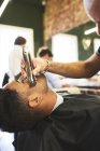 Maschio barbiere rasatura volto del cliente in barbiere — Foto stock